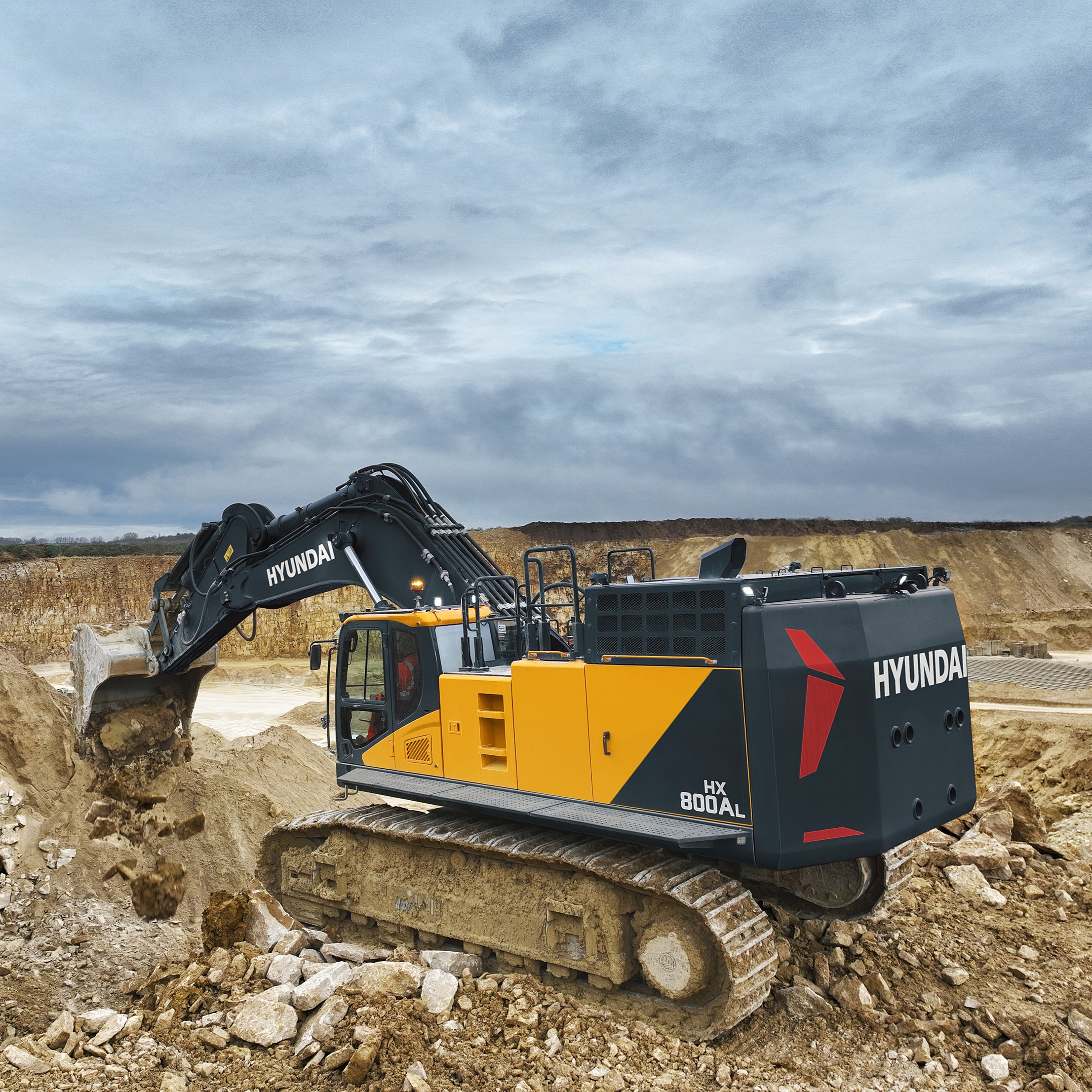 Maak kennis met de HD Hyundai HX1000A L, een nieuwe rupsgraafmachine uit de A-serie, ontworpen voor hoge prestaties tegen lage eigendomskosten. Deze machine is uitgerust met een nieuwe Perkins-motor en de krachtigste in zijn klasse en samen met het hoogste totale hydraulische debiet levert hij ongeëvenaarde prestaties en een ongelooflijke brandstofzuinigheid. Voor superieure veelzijdigheid kunt u de machine met geavanceerde technologieën aanpassen aan uw werkomstandigheden met verschillende vermogens- en werkmodi, plus een giek- en zwenkprioriteit. De HX1000A L is echt klaar voor de uitdaging.